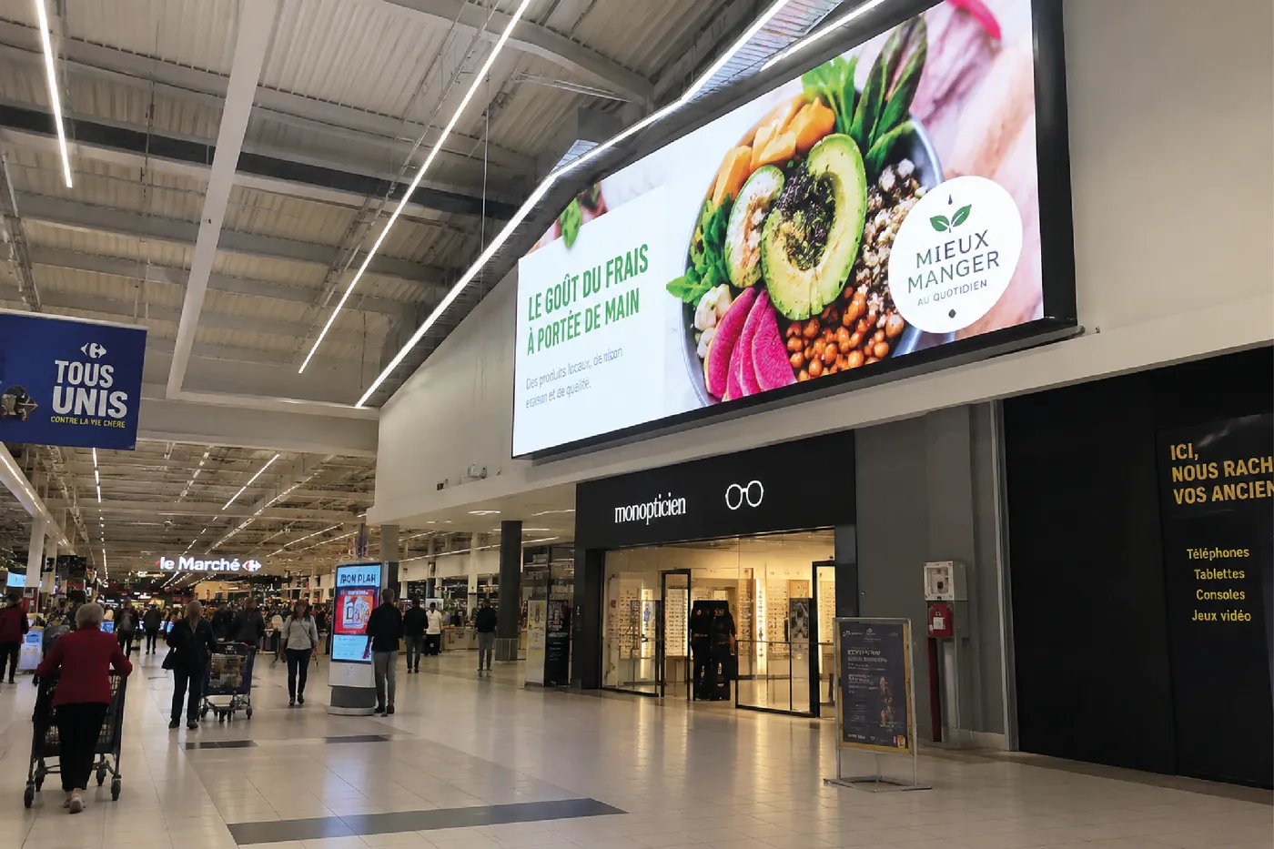 Écran LED grand format diffusant une campagne dans la galerie marchande d'un hypermarché